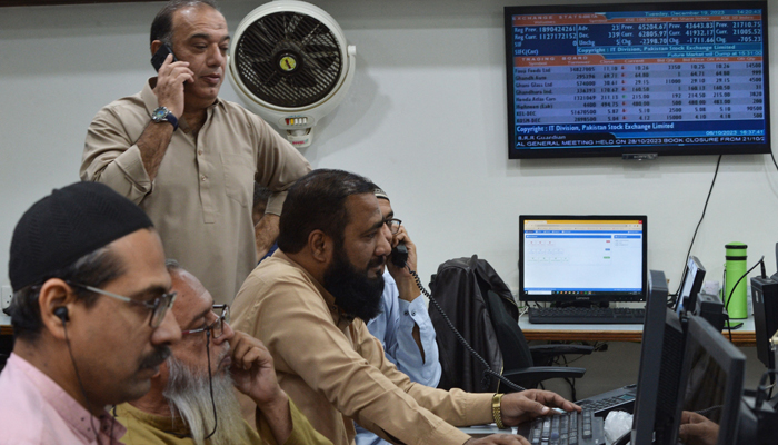 Stock brokers attend phone calls and monitor share prices on their computers during a trading session at the Pakistan Stock Exchange in Karachi on December 19, 2023. — AFP