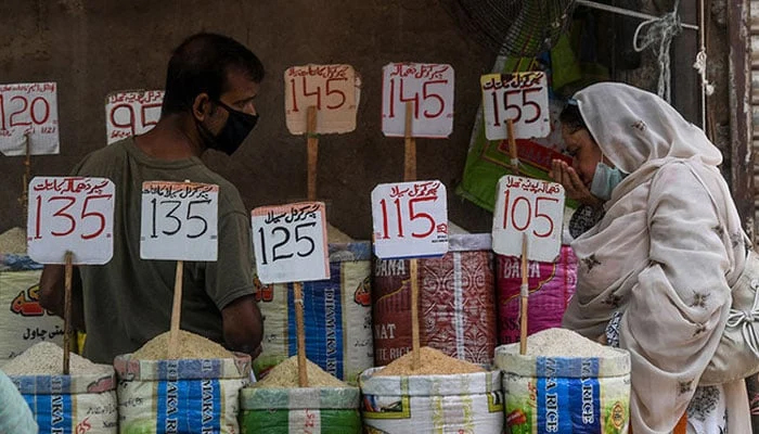 A woman checks the smell of rice at a market in Karachi. — AFP/File