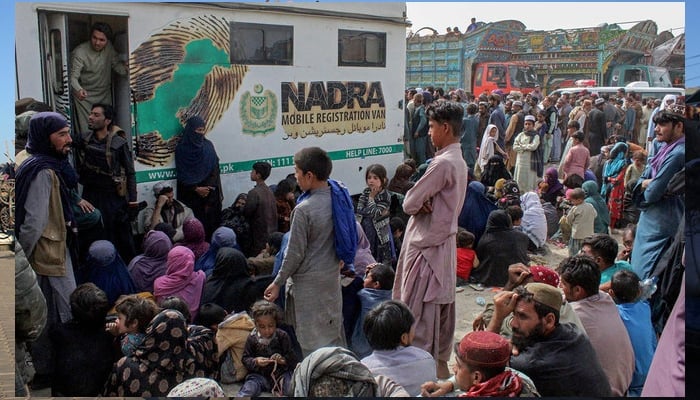 Afghan refugees gather in front of the National Database and Registration Authority (NADRA) vans for biometric verification before their departure to Afghanistan, at a holding centre near Pakistan-Afghanistan border in Chaman on November 1, 2023. — AFP