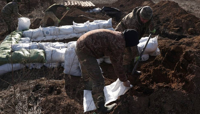 Ukrainian servicemen prepare earthbags to build a fortification not far from the town of Avdiivka in the Donetsk region, amid the Russian invasion of Ukraine, on February 17, 2024. — AFP