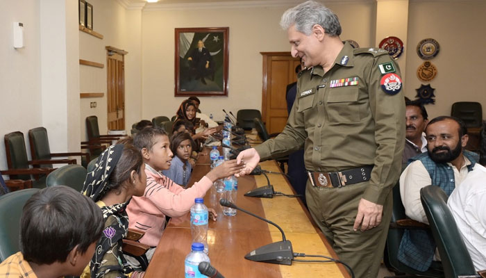 Inspector General (IG) Punjab Dr. Usman Anwar hands to children during visits to Tahaffuz Darsgah. — PUNJAB POLICE Website