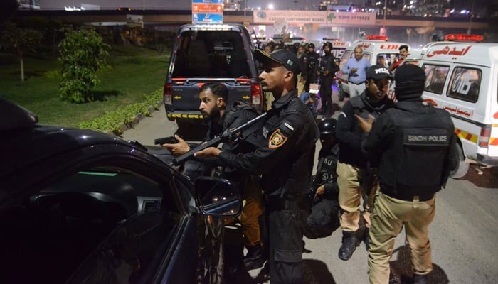 Policemen take position near the site of an attack on a police compound in Karachi on February 17, 2023. — AFP