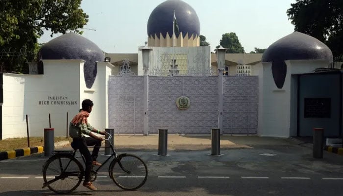 A person passes by on a bicycle in front of the Pakistan High Commission in new Delhi. — AFP/File