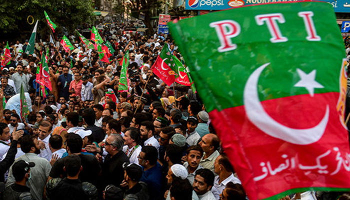 Pakistan Tehreek-e-Insaf supporters hold party flag in rally. — AFP/File