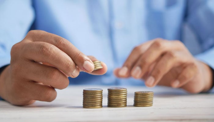 A representational image of a person counting coins. — Unsplash