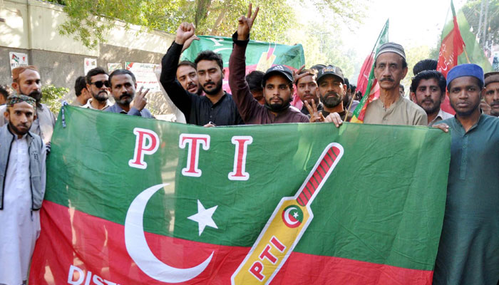 Leaders and supporters of Tehreek-e-Insaf (PTI) hold PTI flag in Hyderabad on February 17, 2024. — PPI