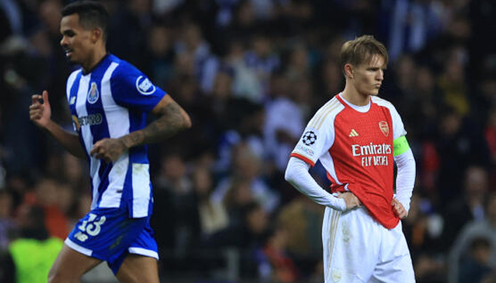 Arsenals Martin Odegaard (R) reacts next to FC Portos Wenderson Galeno during the UEFA Champions League last 16 first leg football match between FC Porto and Arsenal FC at the Dragao stadium in Porto on February 21, 2024. — AFP