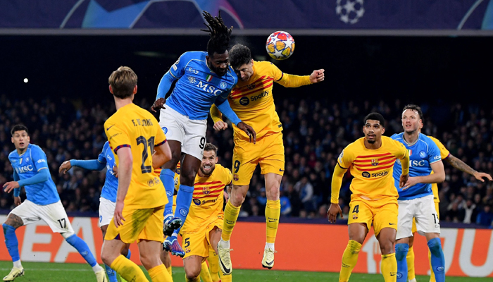 Napolis Andre Zambo Anguissa (CL) vies with Barcelonas Robert Lewandowski (CR) during the UEFA Champions League round of 16 first Leg football match at the Diego-Armando-Maradona stadium, Naples, Italy, Feb. 21, 2024. — AFP