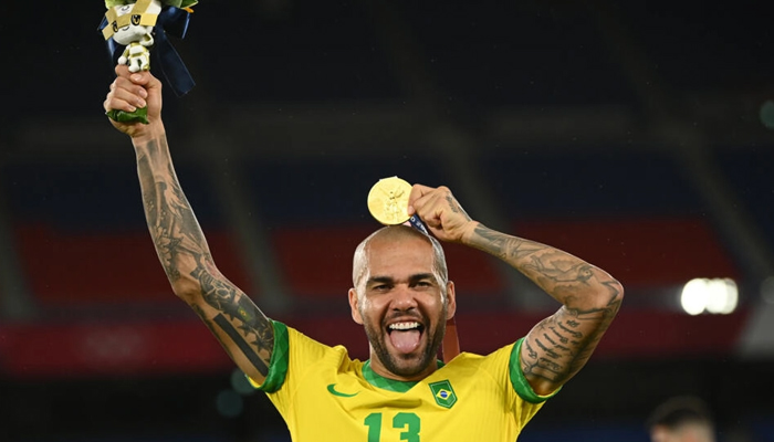 Dani Alves showing off the last addition to his collection of trophies as he receives his Olympic gold medal in Yokohama. — AFP/File