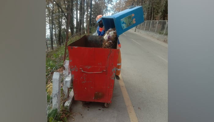 An employee of the RWMC disposes garbage on November 20, 2023, in Islamabad. — Facebook/Rawalpindi Waste Management Company