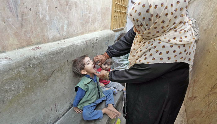 A lady health worker administers polio drops to a child during the polio eradication campaign in Karachi on January 8, 2024. — Online