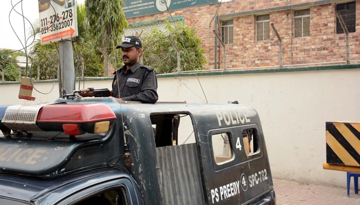 Police official stands alert after an explosion incident Sindh Election Commission office in Karachi on February 3, 2024. — PPI