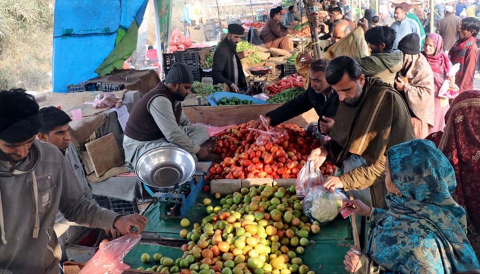 People buy vegetables at Weekly Market located in the Shadman area in Lahore on February 18, 2024. — PPI