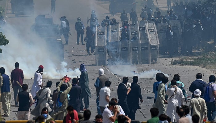 In this photo, taken on May 10, 2023, supporters of former Pakistans Prime Minister Imran Khan clash with policemen during a protest against the arrest of their leader, in Islamabad. — AFP
