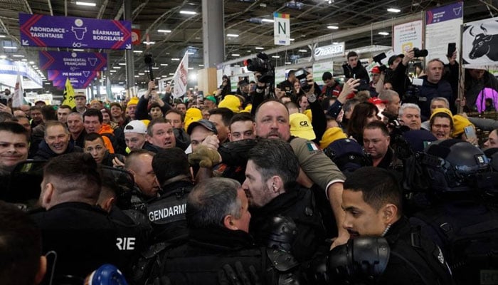 French farmers scuffle with gendarmes (bottom) during a farmers protest at the Porte Versailles exhibition center, prior to the opening of the 60th International Agriculture Fair (Salon de lAgriculture), in Paris on February 24, 2024. — AFP
