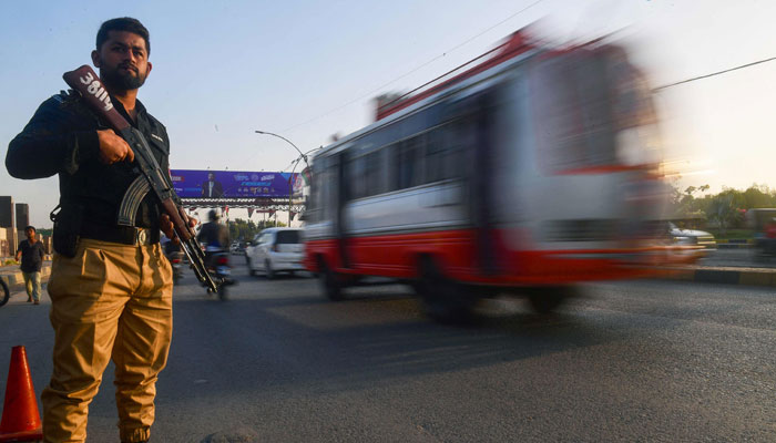 A policeman stands guard along a street in Karachi on February 1, 2024, ahead of the general elections. — AFP