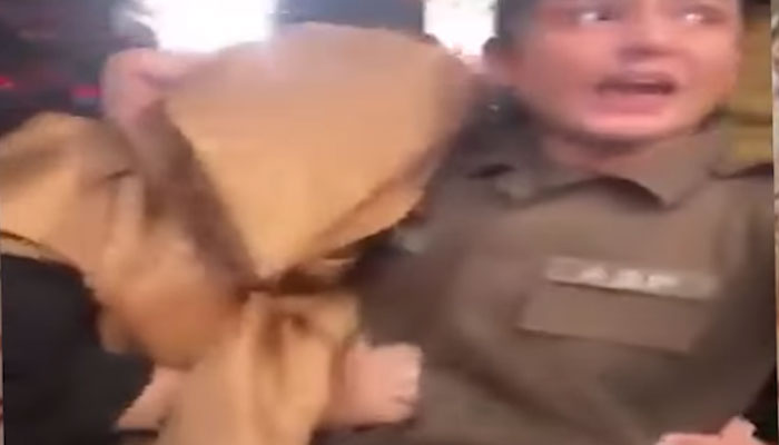 The screenshot shows the brave police officer rescuing the woman from the fury of the angry crowd at Ichhra Bazaar, Lahore. — Facebook