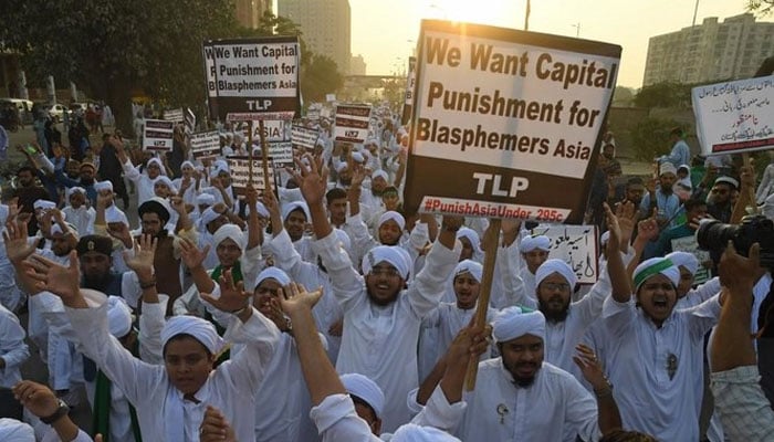 Protester hold banners and placard against blasphemy. — AFP/File