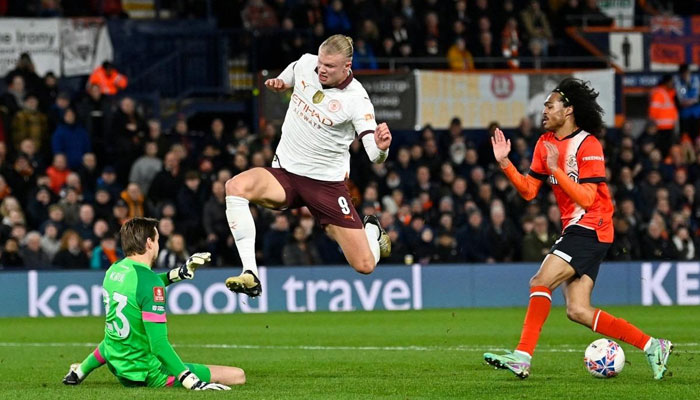 Luton Towns Dutch goalkeeper Tim Krull (left) stops the ball shot by Manchester Citys Norwegian striker Erling Haaland (center) during the English FA Cup fifth round football match between Luton Town and Manchester City at Kenilworth Road stadium in Luton, central England, on February 27, 2024. — AFP