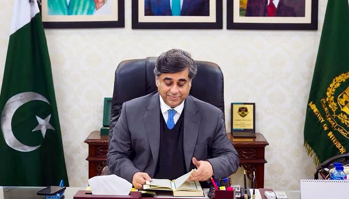 Dr. Gohar Ejaz sits and looks on to the Holy Quran as he assumes the charge as Caretaker Federal Minister of Interior in Islamabad on January 24, 2024. — INP