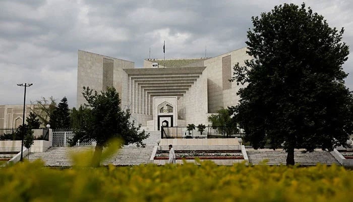 A man uses his mobile phone as he walks past the Supreme Court of Pakistan building in Islamabad, Pakistan May 13, 2023. — AFP