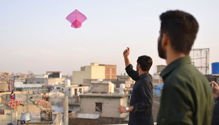 Youths fly kites from a rooftop during the Basant Kite Festival in Rawalpindi. — AFP/File