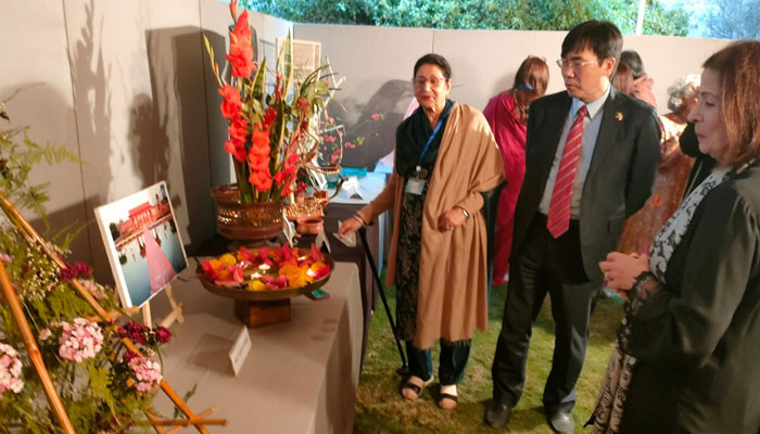 Participants and embassy officials examine various displays during the floral exhibition in Lahore. — Reporter/File