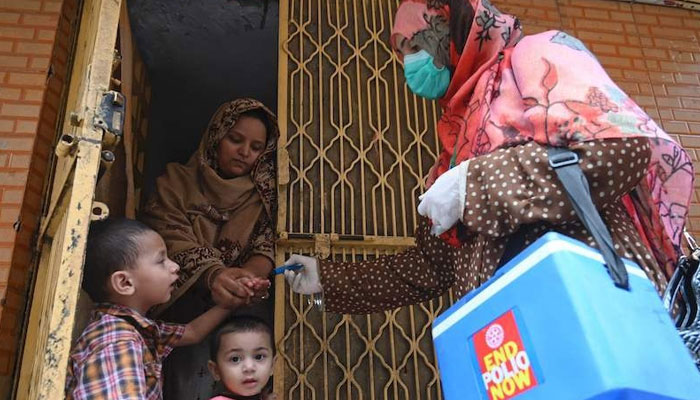 A health worker (right) marks the finger of a child after administering polio vaccine drops during a door-to-door campaign in Lahore on July 20, 2020. — AFP