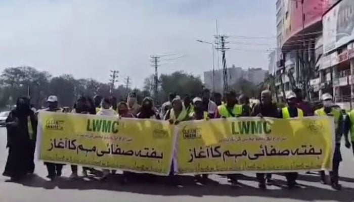 In this screengrab LWMC’s community mobilisation teams and  trade union leaders hold banners during the cleanliness awareness walk on Mall Road and Liberty Market on March 2, 2024. — Facebook/Lahore Waste Management Company