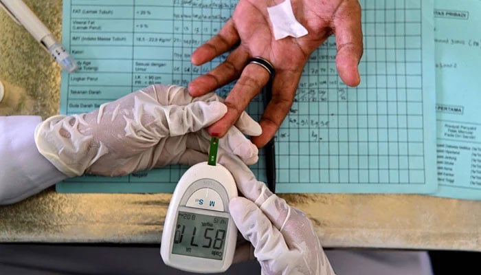 An elderly woman gets her blood tested on December 15, 2021. — AFP