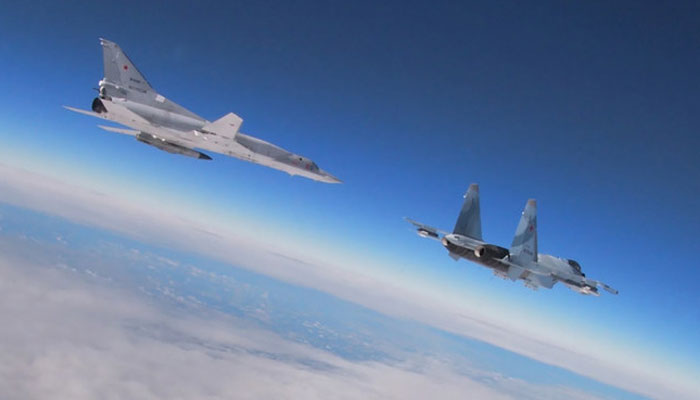 A Su-35 multirole fighter (right) flies alongside a Tupolev Tu-22M3 Backfire strategic bomber during joint exercises of the armed forces of Russia and Belarus. — AFP/File