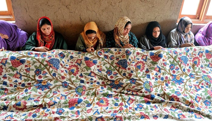 This image shows women doing Kashmiri embroidery on a piece of cloth. — Truly Pakistan Website