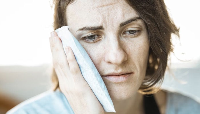 In this representational image, a woman can be seen suffering from ear pain. — Unsplash