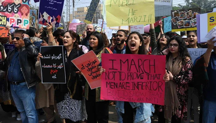 Demonstrators hold placards and shout slogans as they march during the Aurat March to mark International Womens Day. — AFP/File