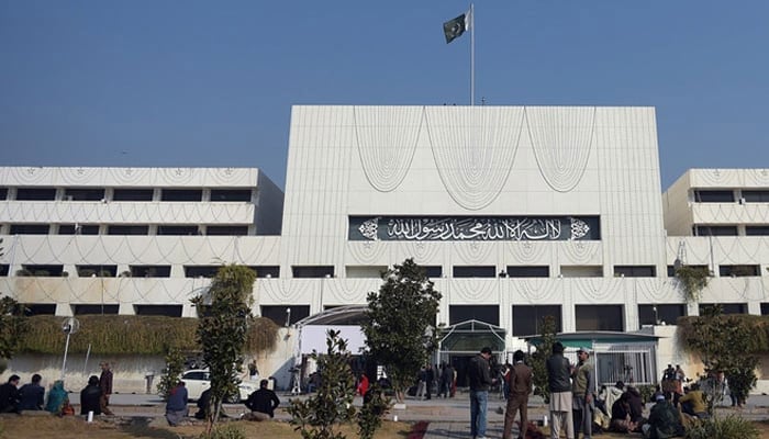 Security and media officials gather in front of the Parliament House building in Islamabad. — AFP/File