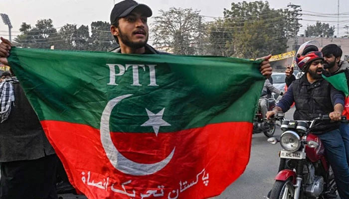 A supporter and activist of Pakistan Tehreek-e-Insaf (PTI) party hold party´s flag in Lahore on January 28, 2024. — AFP