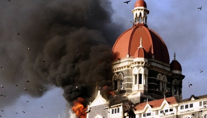 The image shows fire engulfing through a building during the Mumbai attacks on November 26, 2008 in Mumbai, India. — AFP