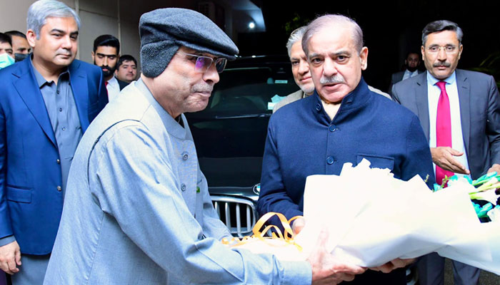 Pakistans Prime Minister Shehbaz Sharif (R) congratulates the newly elected President of Pakistan Asif Ali Zardari on his victory in the Presidential elections with flowers in Islamabad on March 9, 2024. — PPI