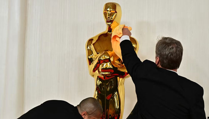 Workers polish an Oscar statue as celebrities arrive for the 96th Annual Academy Awards at the Dolby Theatre in Los Angeles, California, March 10, 2024. — AFP