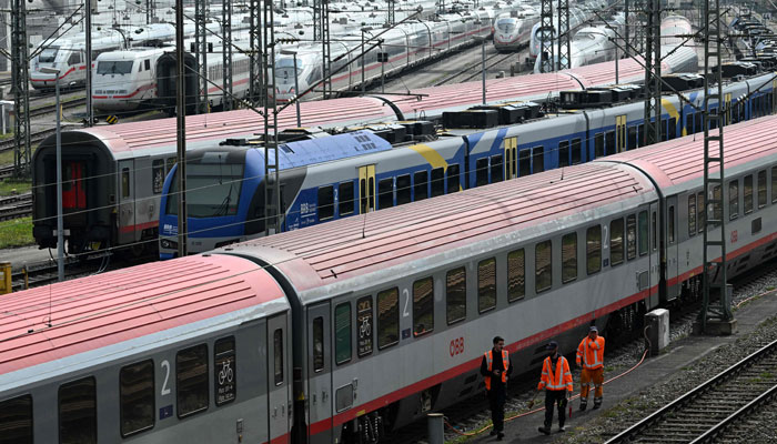 ICE high-speed trains of Germanys railways operator Deutsch Bahn (background), a train of the Austrian railways operator OeBB (foreground) and a regional train (C) are parked on rail tracks in Munich, southern Germany, during a strike of rail workers on April 21, 2023. — AFP
