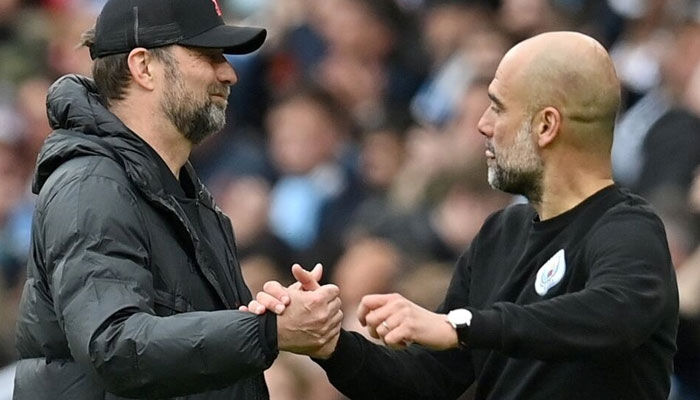 German football manager Jurgen Klopp (L) and Spanish football manager Pep Guardiola interact during a match. — AFP/File