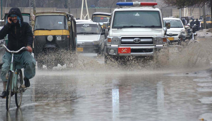 A view of vehicles passing through accumulated rainwater during rain In Quetta on March 6, 2024. — INP