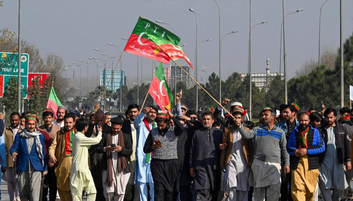 Supporters of PTI block the Peshawar to Islambad highway on Sunday in protest against the alleged skewing of election results in February 8 polls. — AFP/File