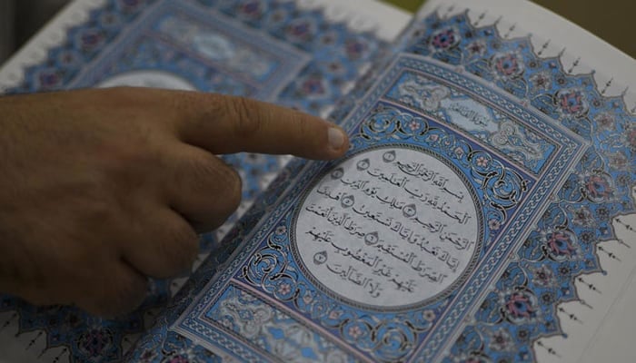 A person pointing finger as he recites the Holy Quran. — AFP/File