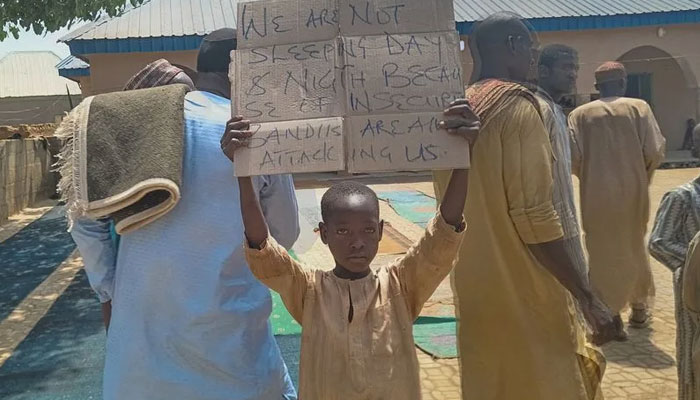 A boy holds a sign to protest against, what a teacher, local councilor and parents said, the kidnapping of hundreds school pupils by gunmen after the Friday prayer, in Kaduna. — AFP FILE