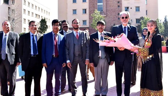 A student presents a flower bouquet to Mehmet Pacaci, Ambassador of the Republic of Türkiye to Pakistan at Comsats University Islamabad (CUI) on March 14, 2024. — Facebook/Comsats University Islamabad