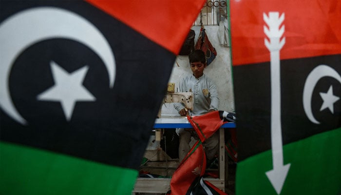 A worker stitches flags of PPP at a factory in Karachi on January 15, 2024, ahead of the upcoming general elections. — AFP