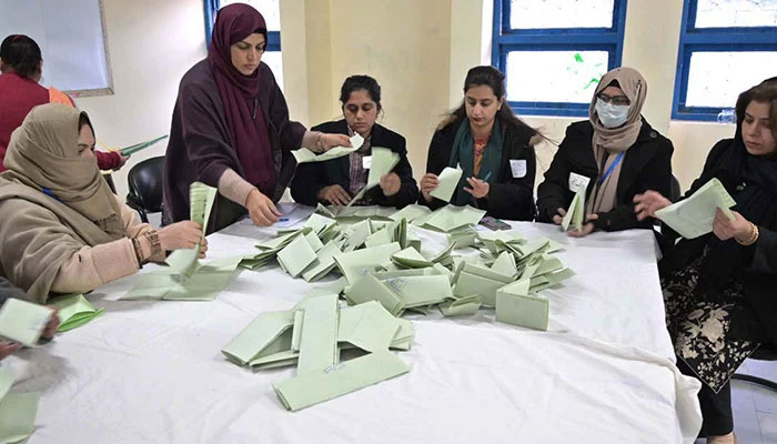 Polling officials count votes at a polling station in F-6 area, Islamabad, during general elections 2024. — APP