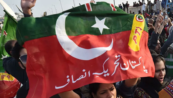 A PTI supporter with a PTI flag held over her head can be seen in this undated photo.—EPA/File