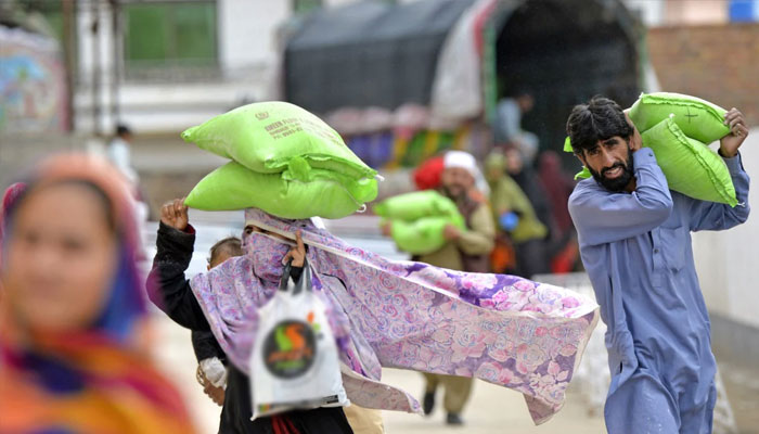 A man and a woman seen carrying bags of flour in this undated photo.—AFP/File
